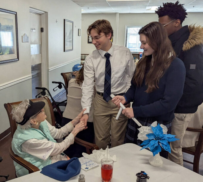 Holy Cross High School Students share holiday spirit at Brookdale Senior Living in Dover