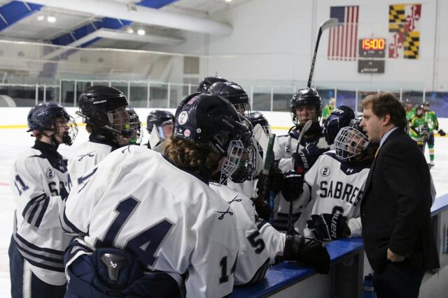 Coach Sammy Gerdano guides his team on the bench during a break in the game.